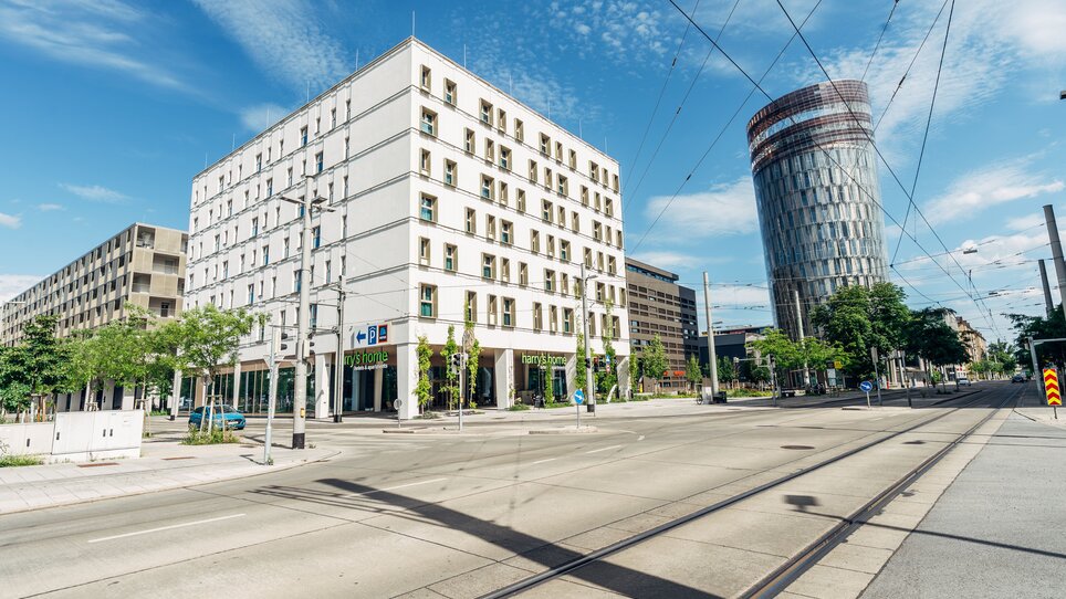 Das harry's home Graz-Smart City Hotel, ein modernes Gebäude und ein Radfahrer. | © harry's home Graz-Smart City