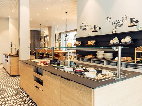 The breakfast area with a variety of foods and a modern ambiance. | © Harrys Home Graz Smart City - Daniel Zangerl