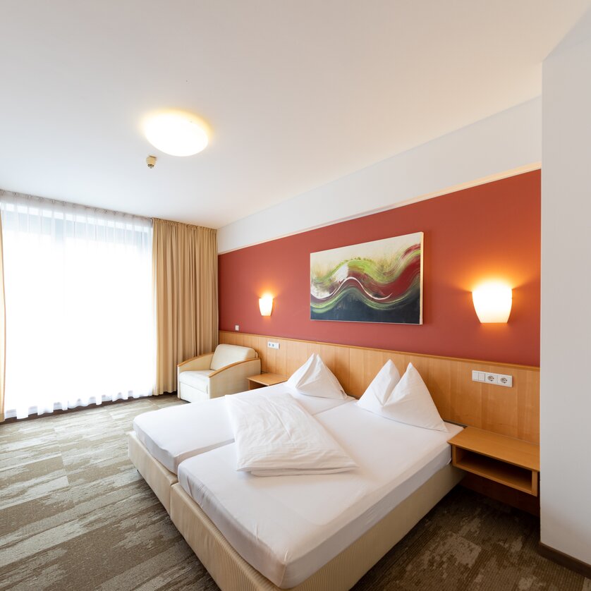 Modernes Doppelzimmer mit zwei Betten und einem Schreibtisch. | © Harry Schiffer