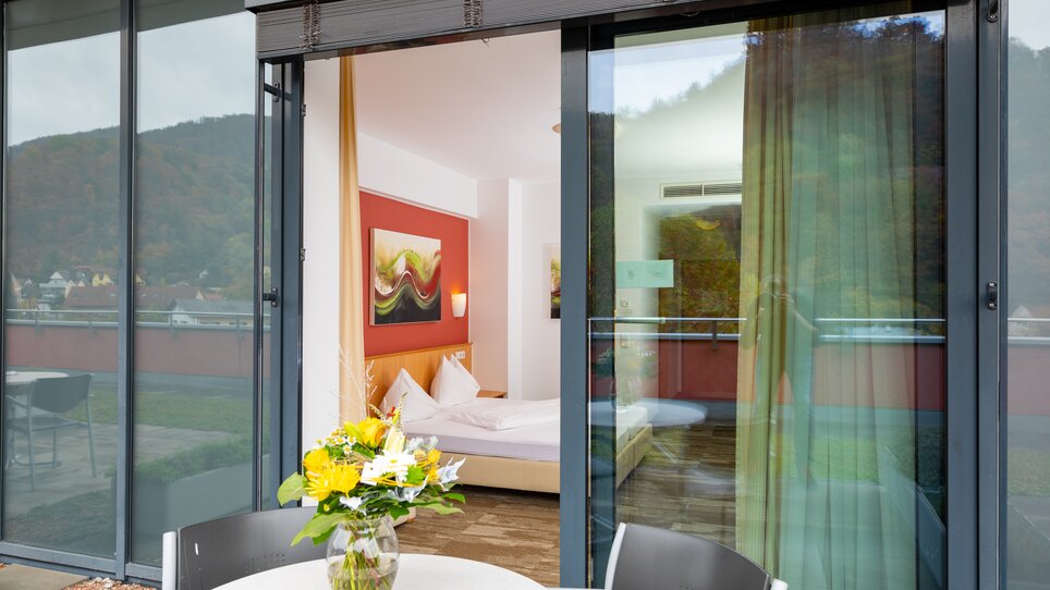 View of a double room with balcony and flower arrangement. | © Harry Schiffer