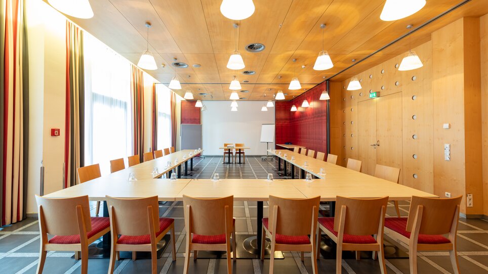 A bright, modern meeting room with a table and chairs. | © Harry Schiffer