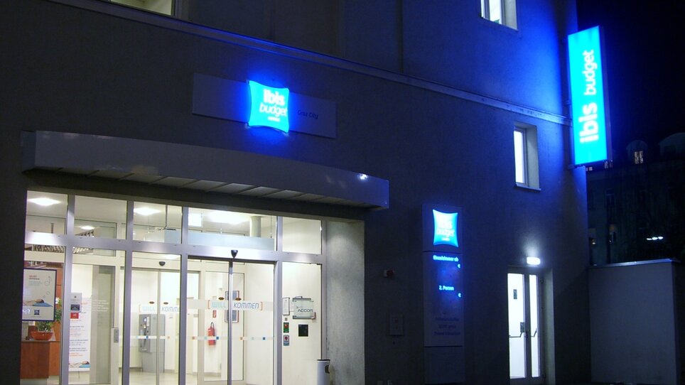 Das IBIS Budget Hotel Graz City mit leuchtenden Schildern bei Nacht. | © Ibis Budget