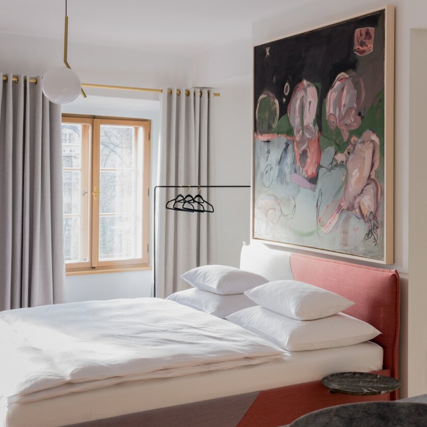 Modern bedroom with large bed and artwork. | © KAI 36