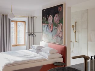 Modernes Schlafzimmer mit großem Bett und Kunstwerk. | © KAI 36