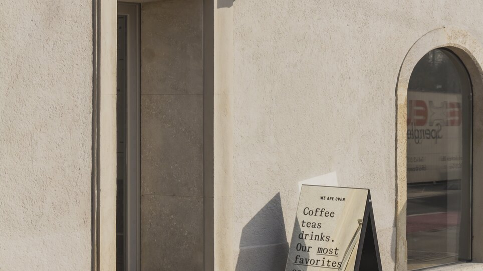 Eingang des Hotel KAI 36 mit Schildern für Kaffee und Getränke. | © KAI 36