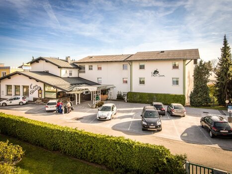 Vista esterna dell'Hotel Kern Buam con parcheggio e ospiti. | © Hotel Kern Buam