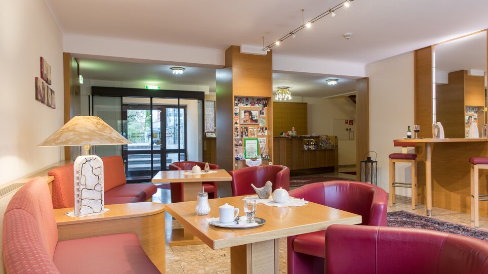 Ein gemütlicher Café-Bereich mit roten Sitzen und Tischen. | © Mario Gimpl