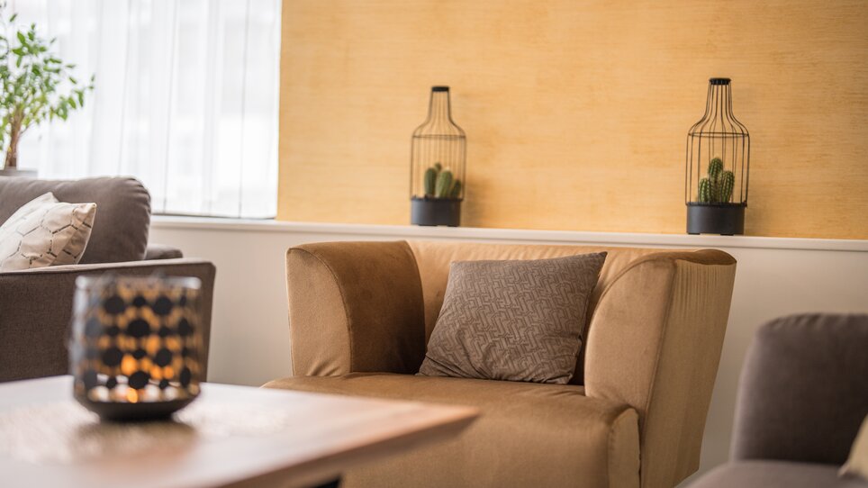 Ein stilvoller Wohnbereich mit beigem Sessel und Pflanzen. | © Mario Gimpl