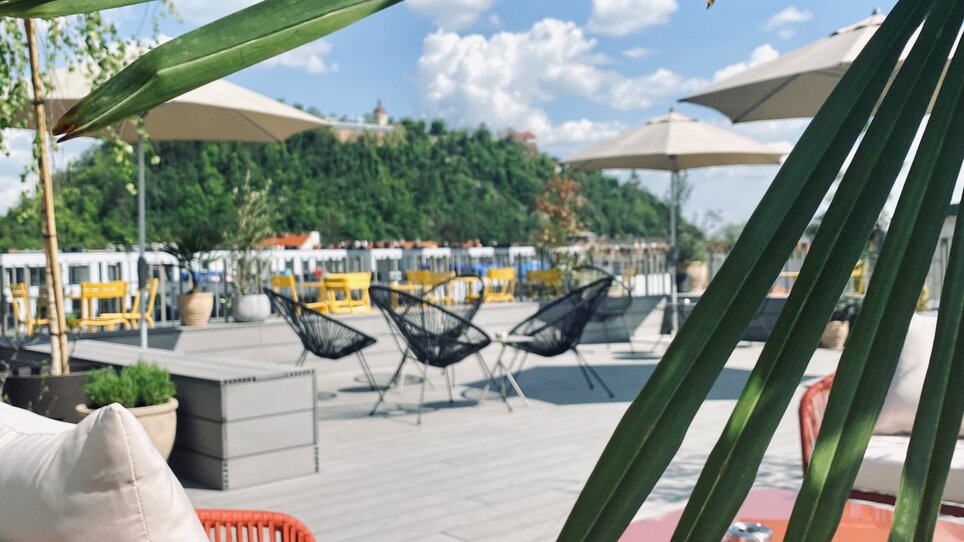 Terrazza accogliente con mobili eleganti, vista sul Schlossberg e dintorni di Graz. | © Lendhotel