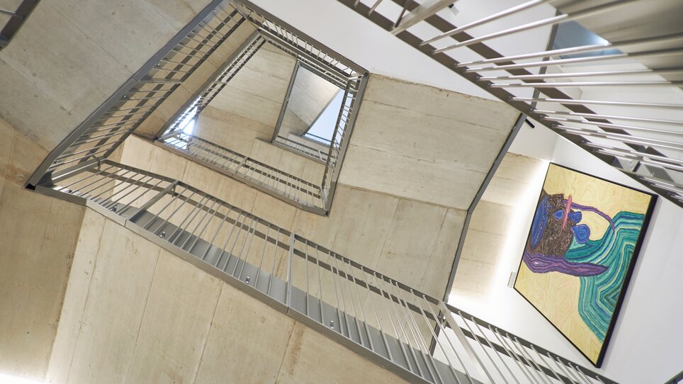 Una moderna scala con un'opera d'arte al muro. | © Lendhotel