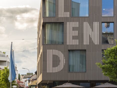Facade of the Lendhotel in Graz featuring large windows and the text "LEND" on the wall. | © Lendhotel