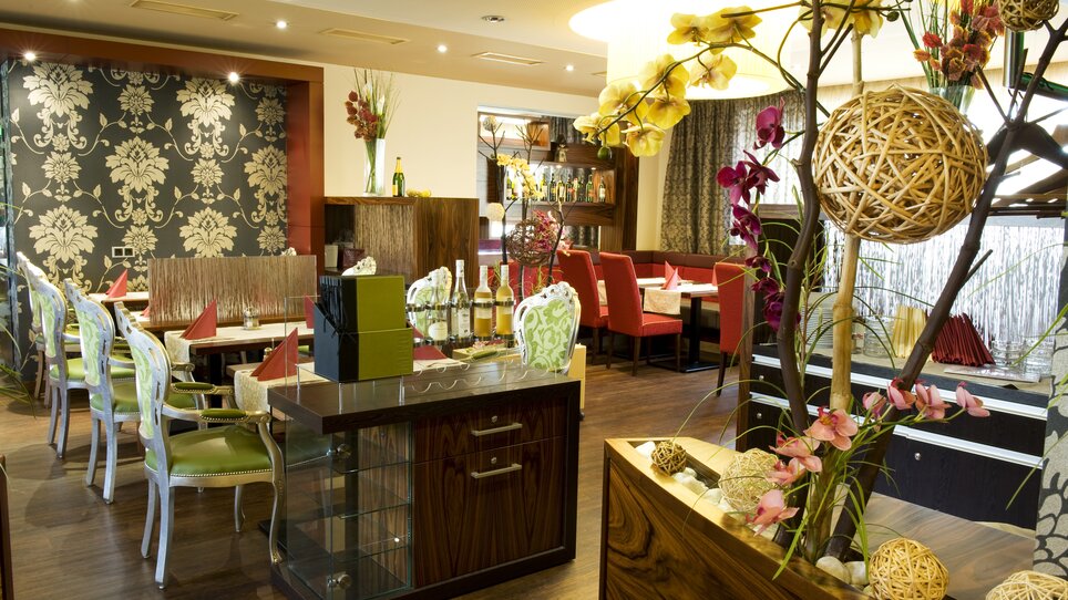Interior view of a stylish restaurant with table decorations and plants. | © Lindenwirt