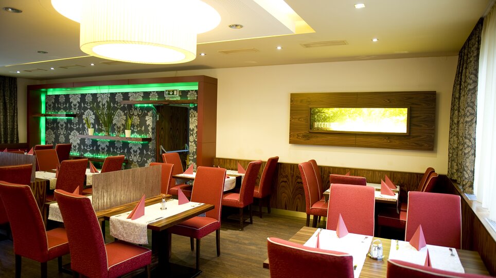 Cozy restaurant with red chairs and tables. | © Lindenwirt