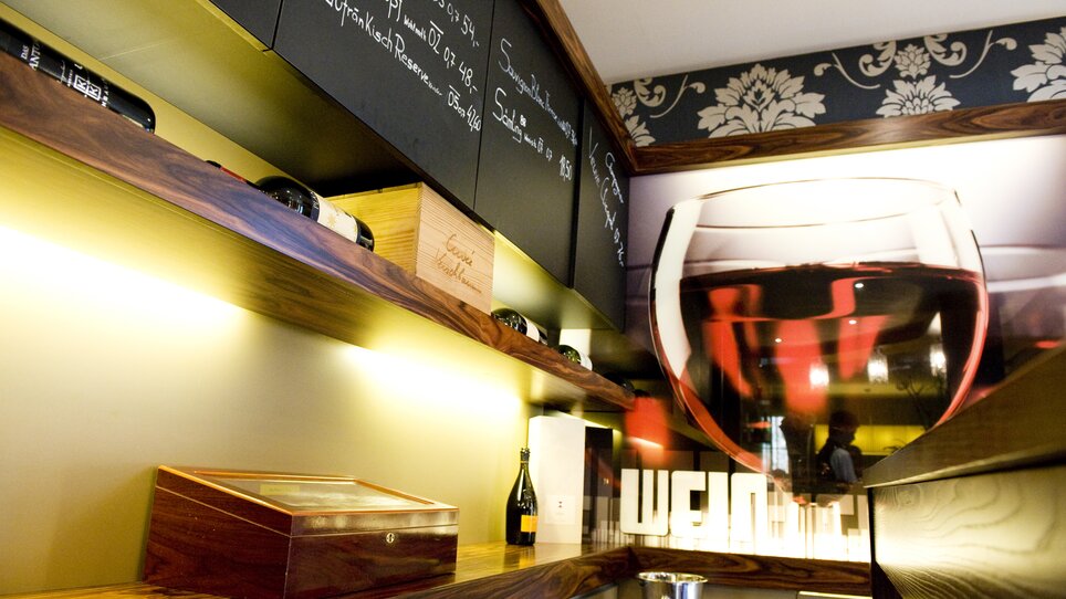 Interior of a wine bar with shelves and wine bottles. | © Lindenwirt