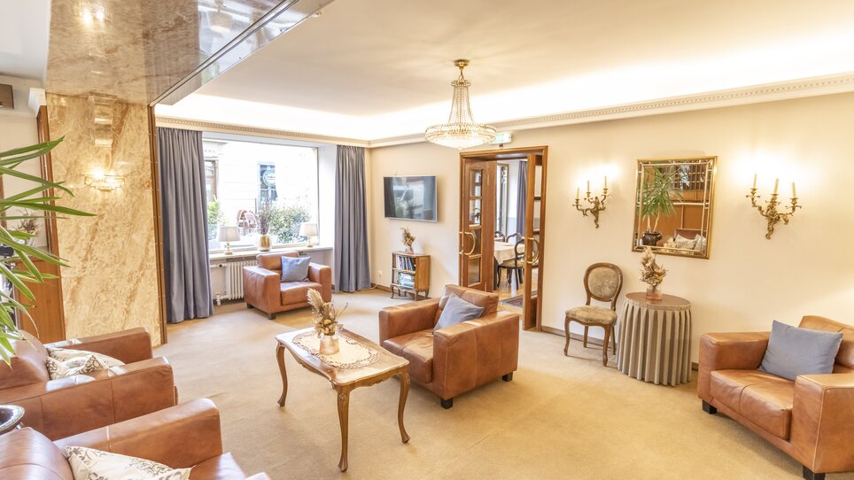 Bright living area with leather armchairs, table, and windows. | © Magdalena Bereźnicka