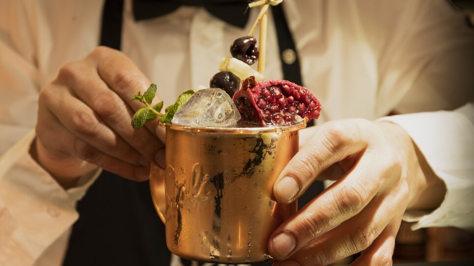 Bartender decorates a cocktail in a copper mug. | © Magdalena Bereźnicka