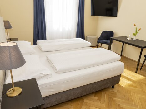 Cozy room with a large bed and a workspace. | © Magdalena Bereźnicka