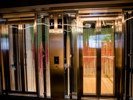 Modern lift system with two cabins and glossy surfaces. | © Motel One Austria GmbH