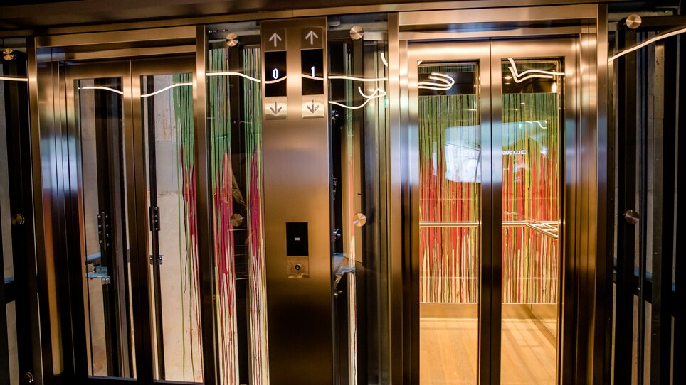Moderne Liftanlage mit zwei Kabinen und glänzenden Oberflächen. | © Motel One Austria GmbH