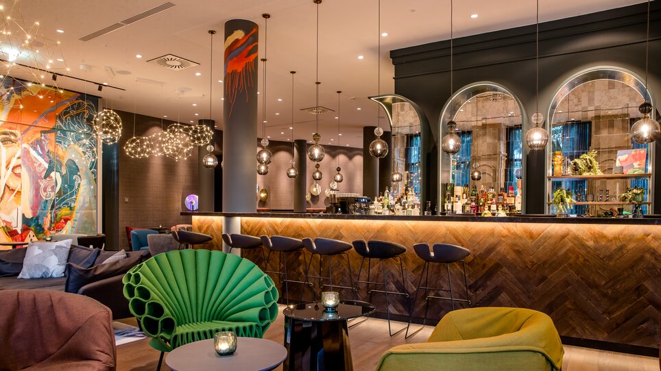 Stylische Bar mit bunten Möbeln und kreativer Dekoration. | © Motel One Austria GmbH