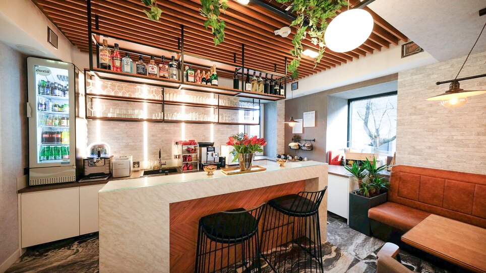Area bar moderna con piante e bevande. | © NED Hotel