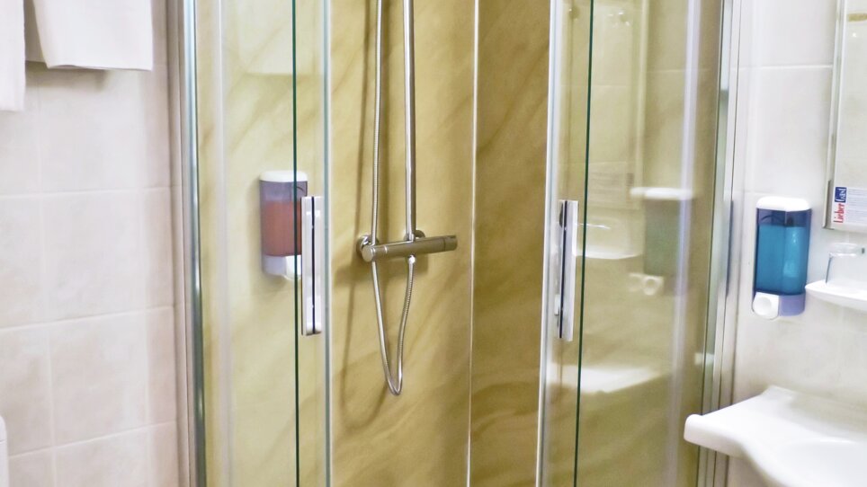 Cabina doccia con pareti di vetro e doccia a pioggia nel un bagno. | © Ulrike Rauch