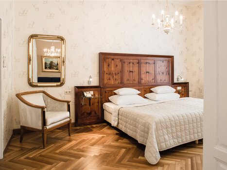 Camera elegante con letto matrimoniale e dettagli in legno. | © Robert Illemann