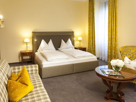 Double room with large bed and cozy seating area. | © Parkhotel Graz