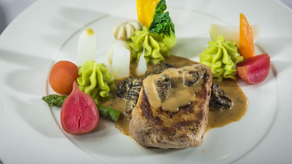 Gourmet dish featuring meat and vegetables on a plate. | © Parkhotel