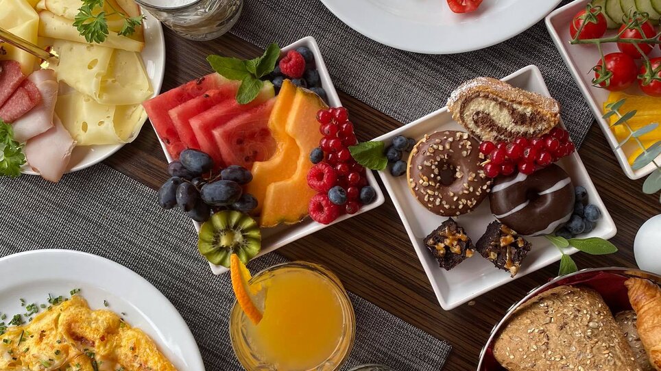 Variety of breakfast options including eggs, fruits, pastries, and drinks. | © PLAZA INN Graz City