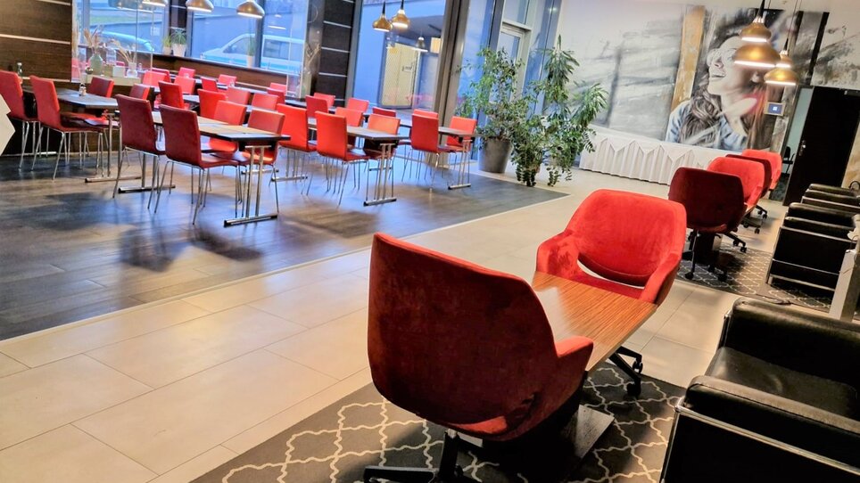 Interior view of the restaurant in Best Western Plus Plaza Hotel Graz with red chairs. | © PLAZA INN Graz City