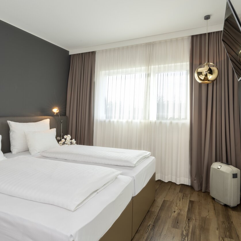 Modern room with double bed and TV. | © Plaza INN Graz