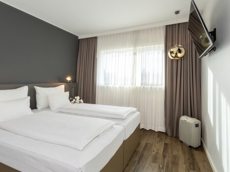 Camera moderna con letto matrimoniale e TV. | © Plaza INN Graz