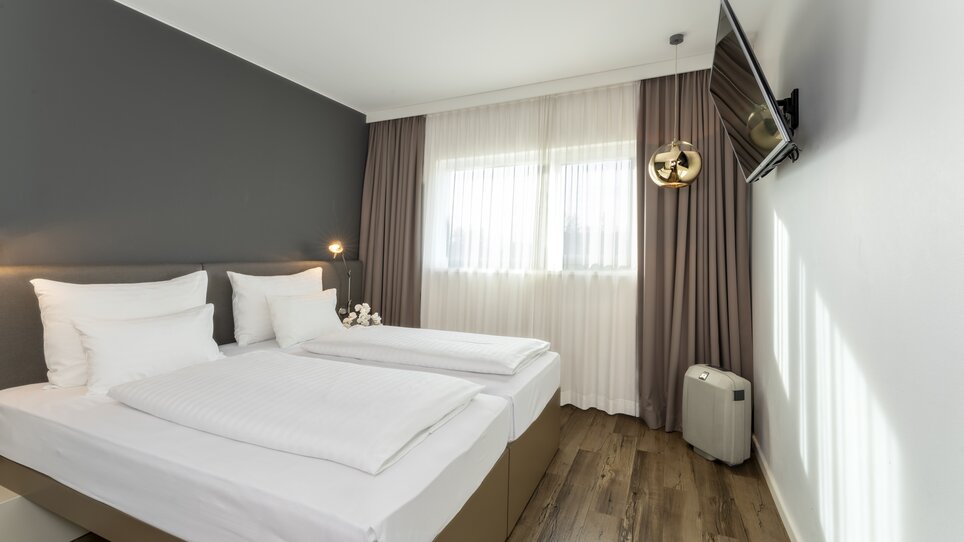 Modern room with double bed and TV. | © Plaza INN Graz