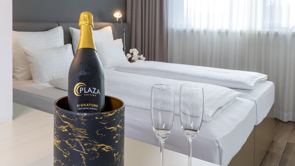 Double room with champagne and two glasses. | © Plaza INN Graz