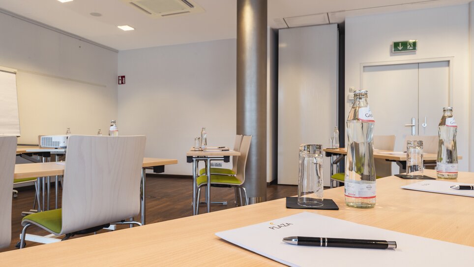 Conference room in hotel with tables and water bottles. | © Plaza INN Graz
