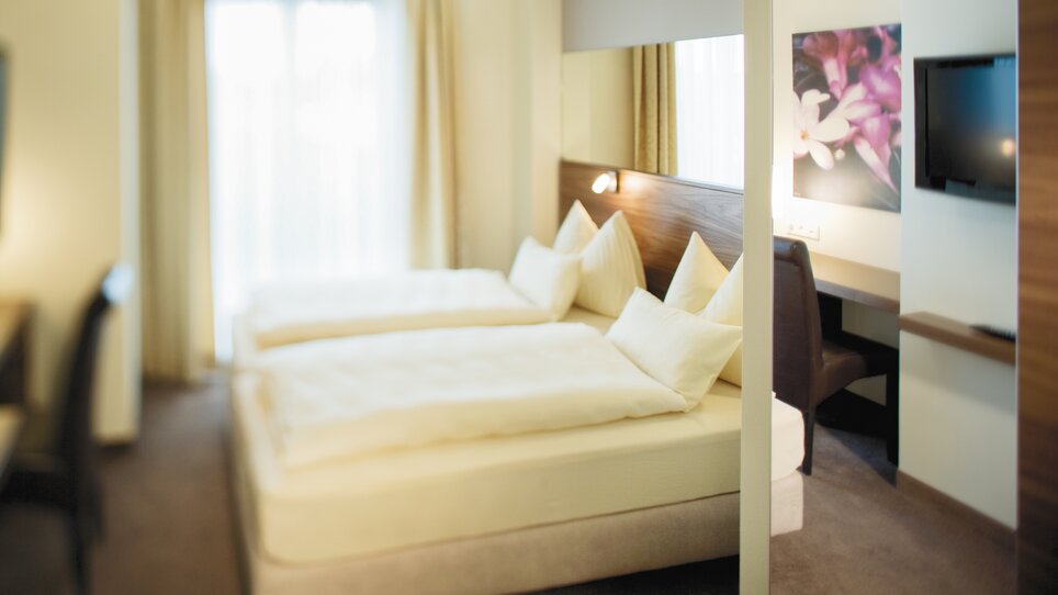 Spacious double room with two beds and pillows. | © Roemerstube