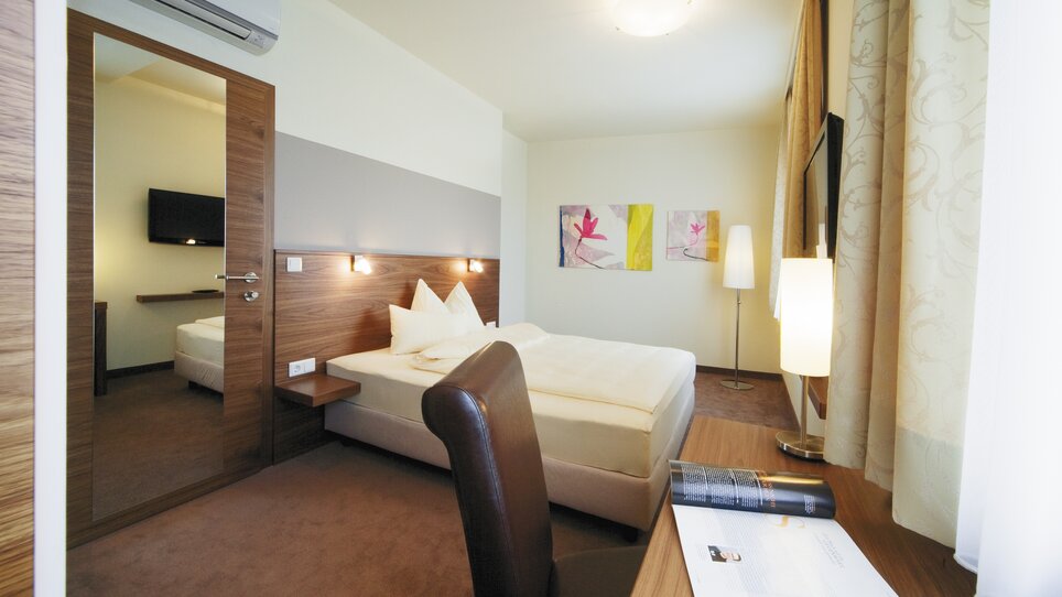 Bright double room with large bed and TV. | © Roemerstube 