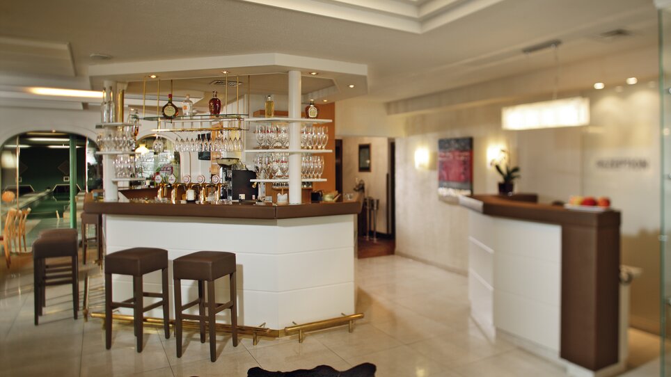 Modern bar with glasses and stools in the reception area. | © Roemerstube