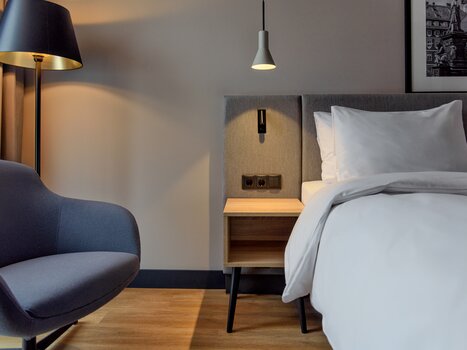 Modern double room with a comfortable armchair and bed | © Christoph Schubert