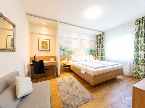 Bright room with double bed, desk and sofa. | © Hotel Süd Art