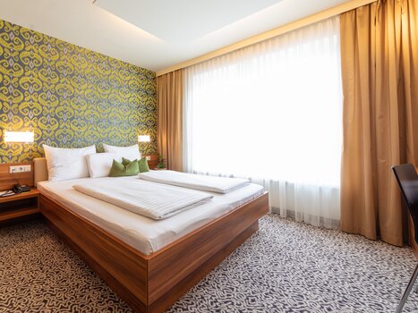 Bright double room with large bed and window. | © Hotel Süd Art