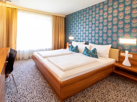 Modern room featuring a double bed with decorative pillows. | © Hotel Süd Art