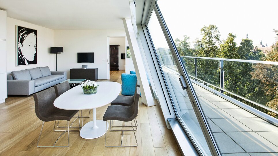 Bright living room with dining area and large windows. | © Schlossberghotel