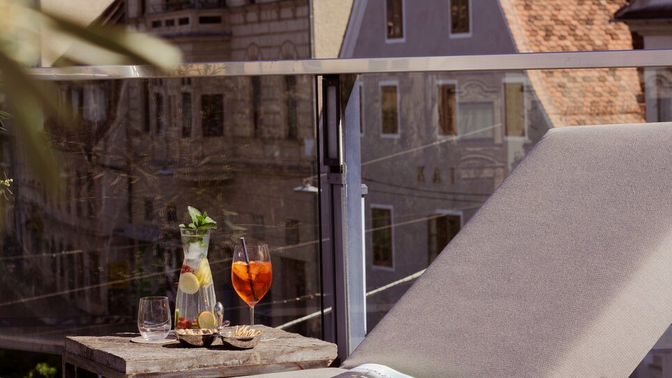 Relaxing terrace with cocktails and a magazine. | © Schlossberghotel