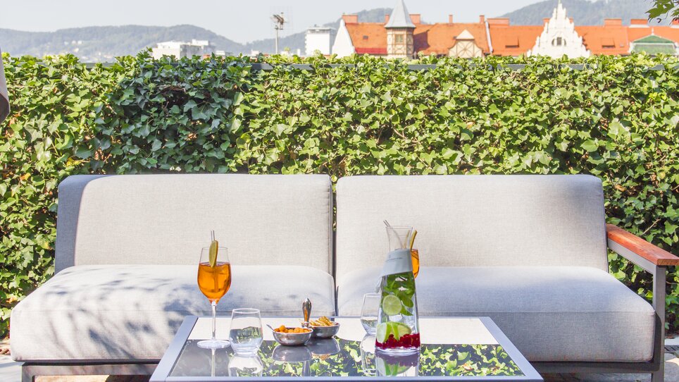 Seating on the terrace with drinks and snacks. | © Schlossberghotel