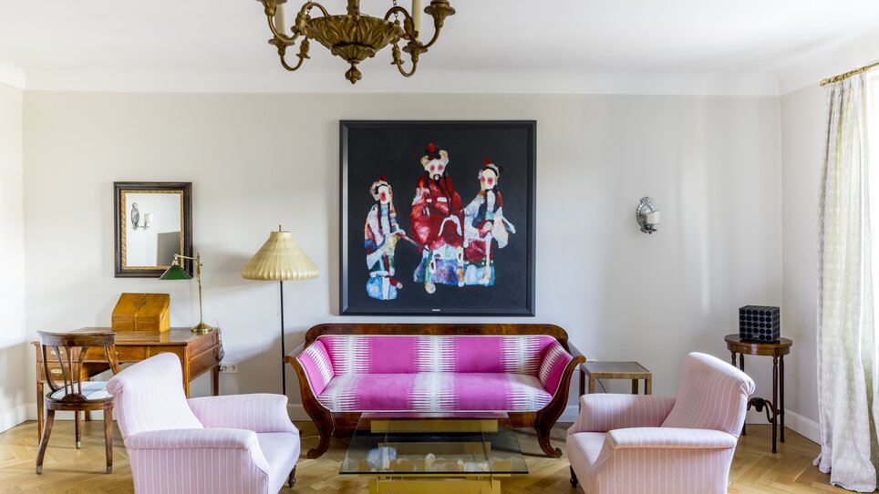 Modern living area with colorful sofa and artwork. | © Schlossberghotel