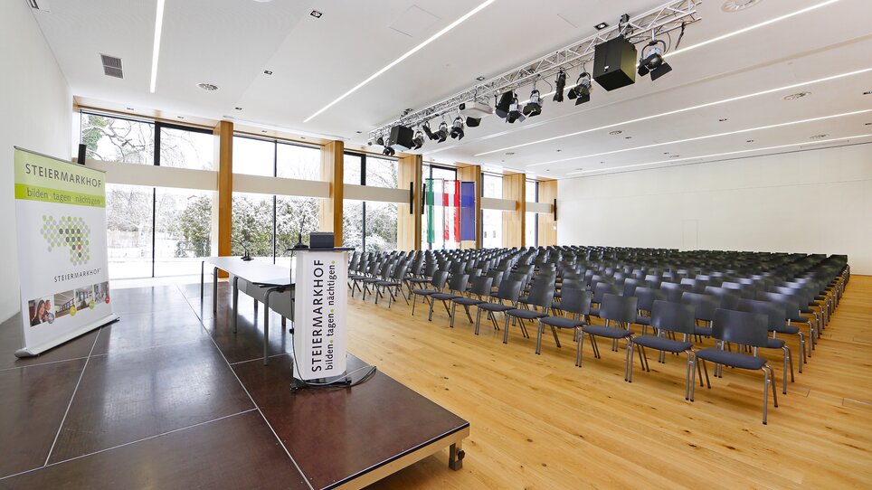 Room in Steiermarkhof with stage and chairs for an event. | © Foto Pachernegg