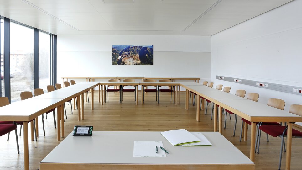 A meeting room with tables, chairs, and a picture on the wall. | © Foto Pachernegg
