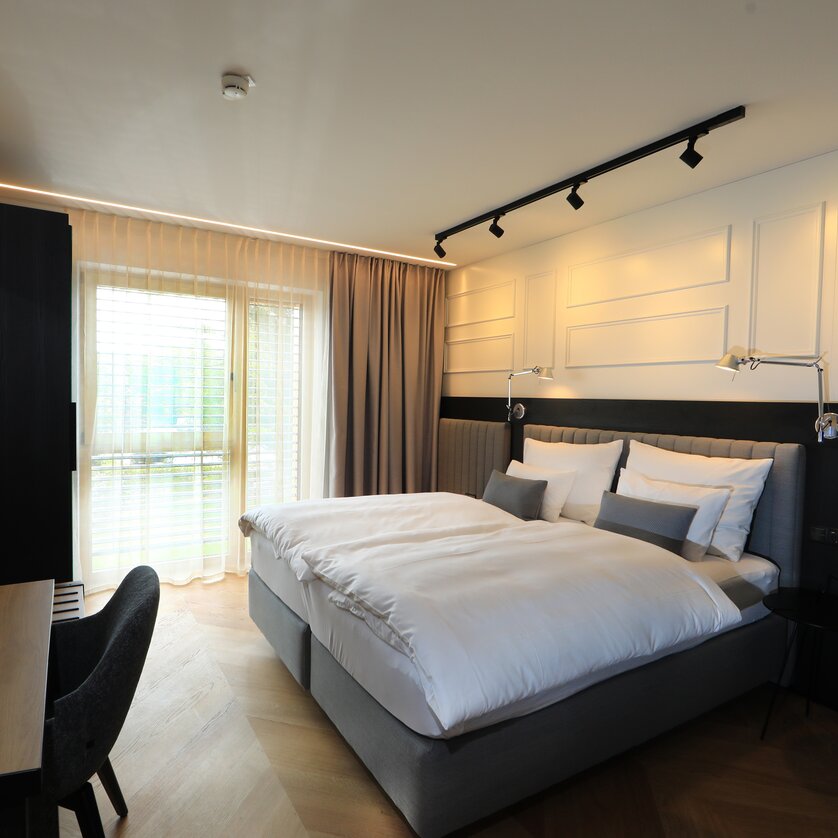 Una camera luminosa con letto matrimoniale e area di lavoro. | © Hotel Steiermarkhof